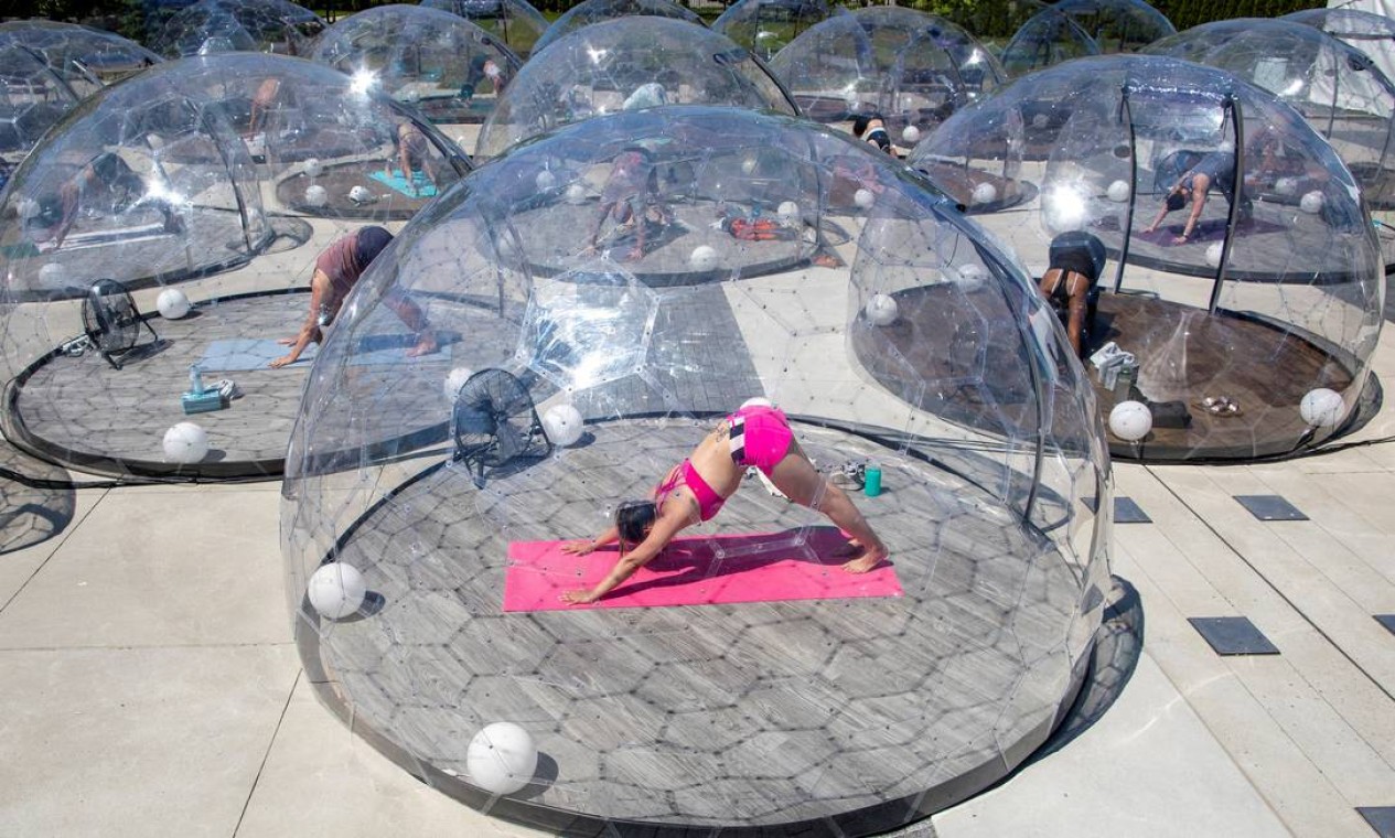 Junho - Pessoas participam de uma aula de ioga ao ar livre, em uma cúpula para facilitar o distanciamento social e protocolos adequados para prevenir a propagação do coronavírus, em Toronto, Canadá Foto: CARLOS OSORIO / REUTERS - 21/06/2020