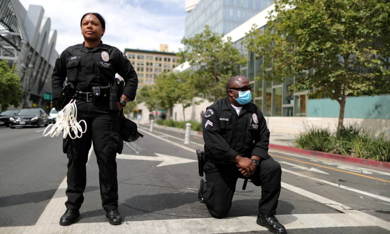 Julho - Policial negro se reverencia protesto contra a violência policial e racismo, motivados pelo caso George Floyd, ao lado da delegacia de polícia de Los Angeles, na Califórnia, EUA Foto: LUCY NICHOLSON / REUTERS - 02/07/2020
