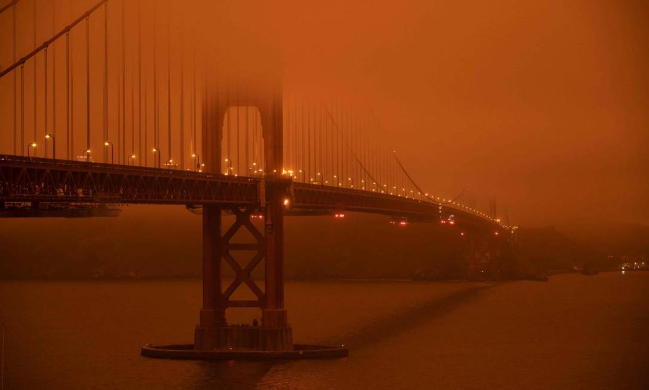 Setembro - Carros passam pela Golden Gate, em São Francisco, sob um céu laranja, causado pelos incêndios florestais fora de controle na Califórnia que passaram de 800 mil hectares de destruição Foto: HAROLD POSTIC / AFP - 09/09/2020