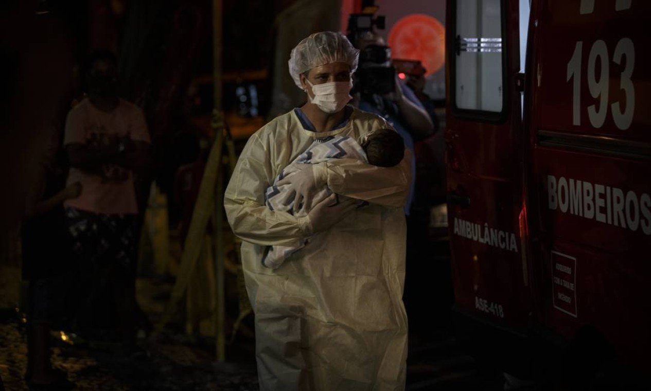Funcionário do Hospital Geral de Bonsucesso carrega bebê nos braços para transferi-lo para outra unidade após incêndio Foto: Alexandre Cassiano / Agência O Globo - 27/10/2020