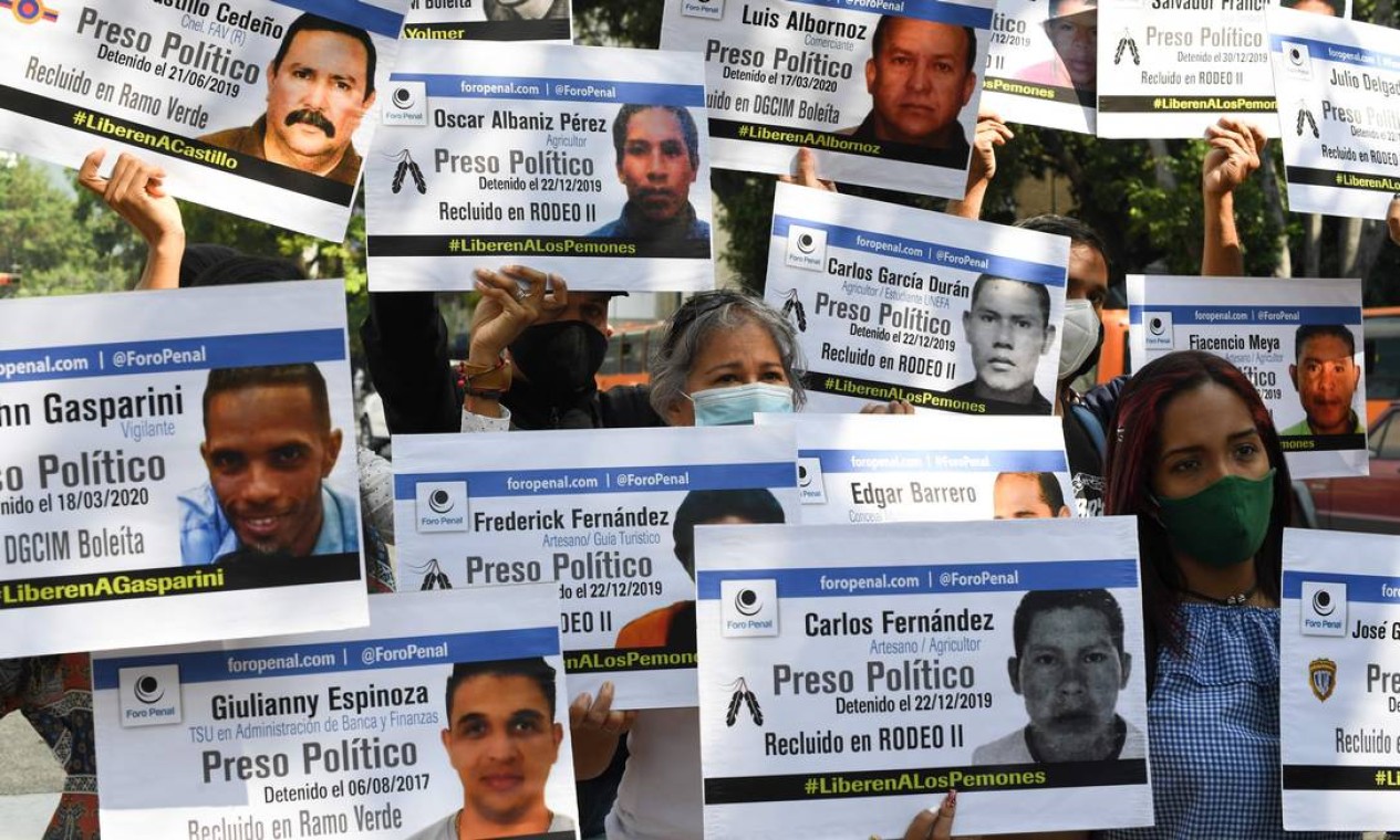 Parentes de opositores do governo que permanecem detidos em diferentes prisões seguram cartazes com seus retratos e nomes durante protesto convocado pela ONG de direitos humanos Foro Penal no âmbito da campanha "Natal sem Prisioneiros Políticos", em Caracas. O protesto ocorre em 14 estados venezuelanos simultaneamente, segundo porta-vozes do Foro Penal Foto: YURI CORTEZ / AFP