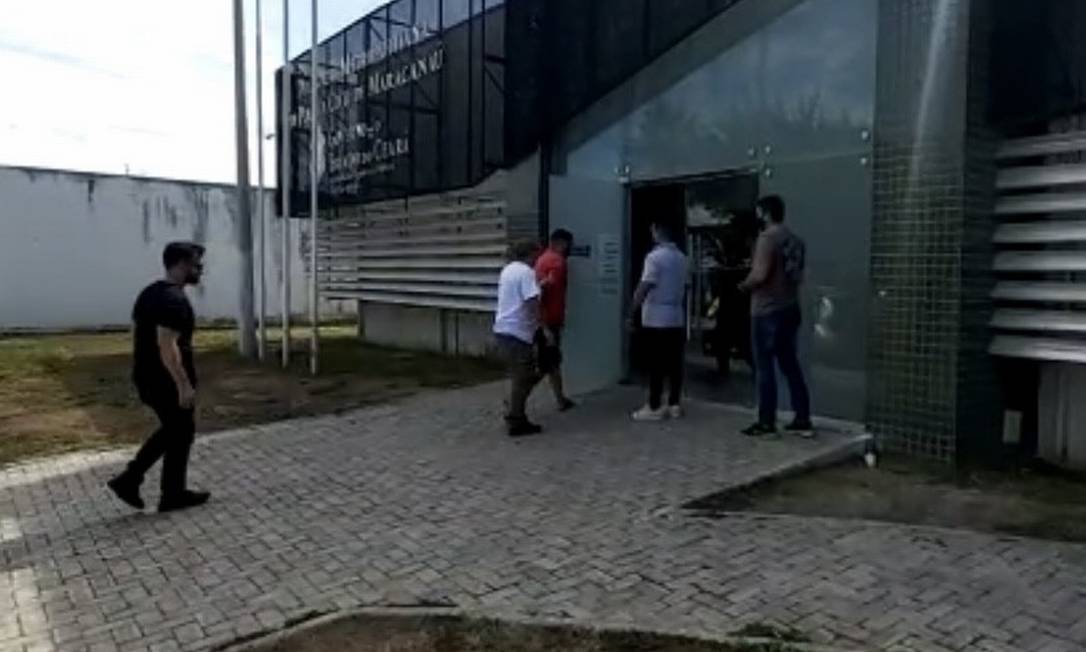 O preso, de camisa laranja, chega a uma unidade policial em Fortaleza Foto: Reprodução