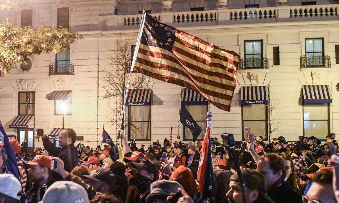 Apoiadores do presidente Donald Trump agitam uma bandeira representanto as 13 colônias americanas originais durante um protesto em Washington, DC Foto: STEPHANIE KEITH / AFP/12-12-2020