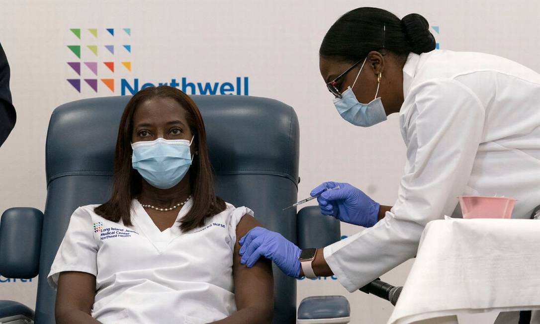 Sandra Lindsay, uma enfermeira da UTI no Long Island Jewish Medical Center em Queens, em Nova York, recebendo a vacina contra Covid-19 Foto: Mark Lennihan/Via NYT