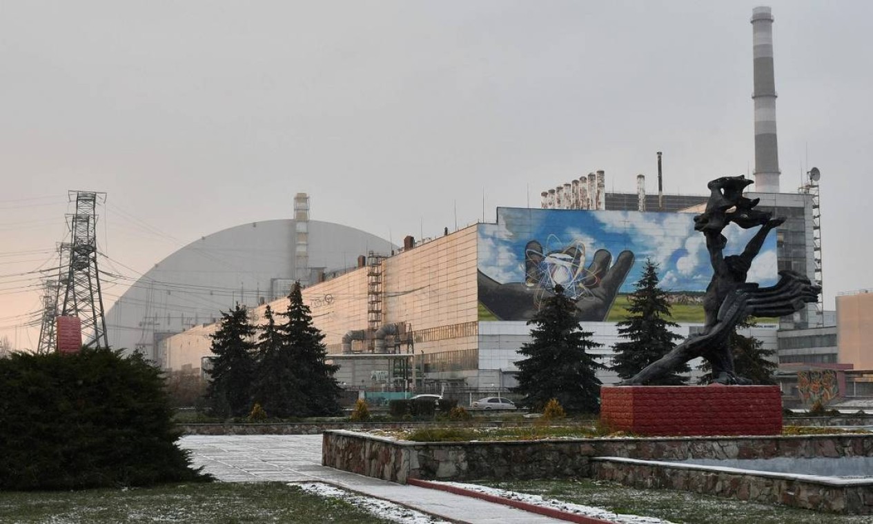 Um monumento em frente ao prédio onde ficava o reator que explodiu na usina nuclear de Chernobyl, na Ucrânia Foto: GENYA SAVILOV / AFP