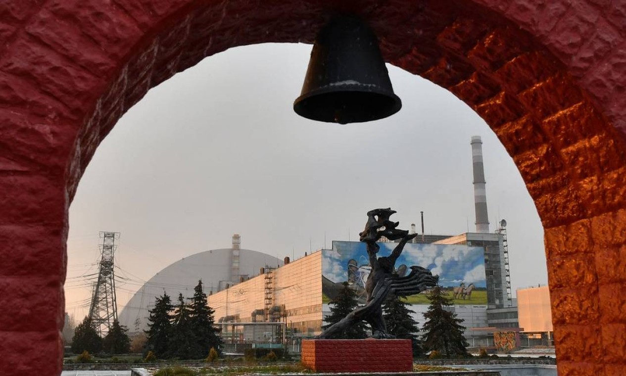 Um monumento em frente ao prédio onde ficava o reator que explodiu na usina nuclear de Chernobyl, na Ucrânia Foto: GENYA SAVILOV / AFP