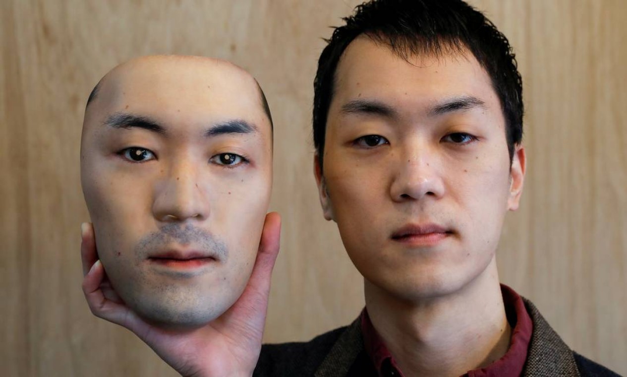 Shuhei Okawara, de 30 anos, segura uma máscara hiper-realista baseada em seu rosto real, feita com tecnologia de impressão 3D, em Tóquio, Japão Foto: ISSEI KATO / REUTERS