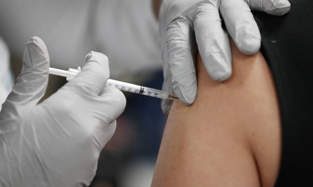 Profissional de saúde recebe vacina da Pfizer-BioNtech contra Covid-19 em Miami, nos EUA Foto: JOE RAEDLE / AFP