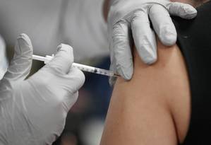 Profissional de saúde recebe vacina da Pfizer-BioNtech contra Covid-19 em Miami, EUA Foto: JOE RAEDLE / AFP