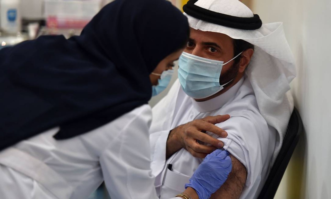 Ministro da Saúde da Arábia Saudita, Tawfiq al-Rabiah, recebe a vacina contra o coronavírus Foto: FAYEZ NURELDINE / AFP