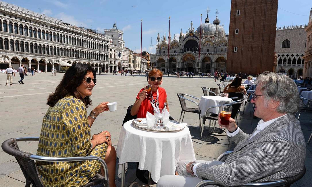 Frequentadores do Caffè Florian aproveitam as mesas ao ar livre na Praça São Marcos, em Veneza Foto: ANDREA PATTARO / AFP