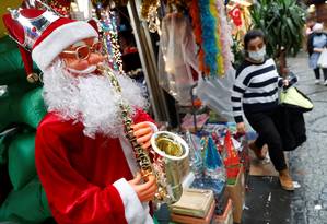 Uma mulher usa uma máscara protetora quando sai da loja de Natal e Ano Novo.  Foto: Murad Sezer / Reuters