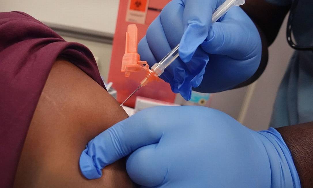 Trabalhador de saúde é vacinado contra a Covid em hospital de Chicago, EUA: mudança de perspectiva no mercado com a potencial imunização Foto: SCOTT OLSON / AFP