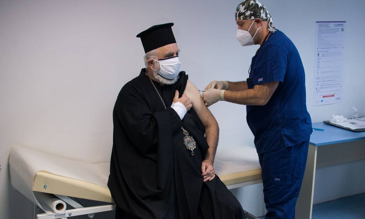Bispo cristão ortodoxo Tihon recebe a primeira dose da vacina Pfizer/BioNTech, contra a Covid-19, no Hospital de Santana, em Sofia.A Bulgária começou vacinação com um primeiro lote de 9.750 doses Foto: NIKOLAY DOYCHINOV / AFP