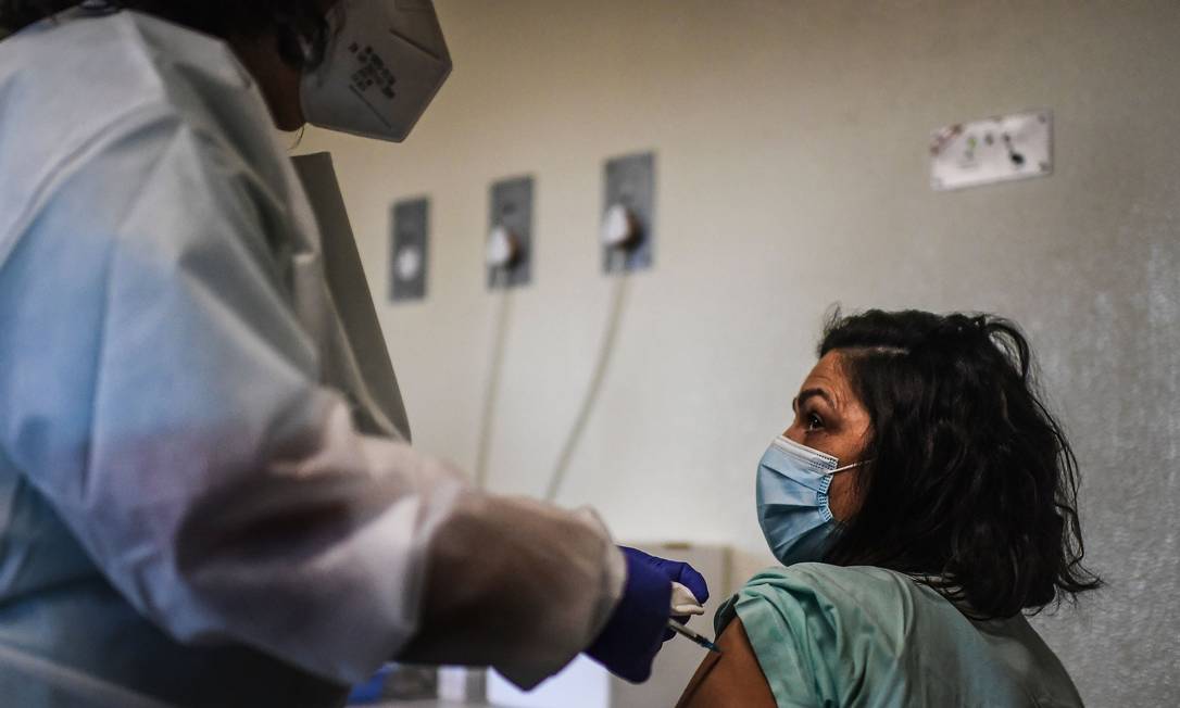 Profissional de saúde é vacinada no hospital Santa Maria, em Lisboa, Portugal, neste domingo (27) Foto: PATRICIA DE MELO MOREIRA / AFP