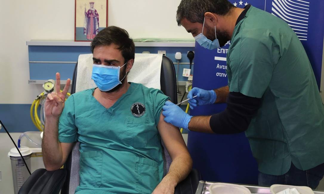 O médico Christos Kypri recebe sua primeira dose da vacina Pfizer/BioNTech COVID-19 no Hospital Geral Famagusta, na aldeia cipriota de Deryneia Foto: YIANNIS KOURTOGLOU / AFP