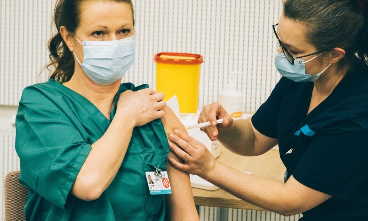 A enfermeira Andrea Nummi recebe a vacina da Pfizer/Biontech no Hospital Universitário de Helsinque, em Helsinque, Finlândia Foto: ALESSANDRO RAMPAZZO / AFP