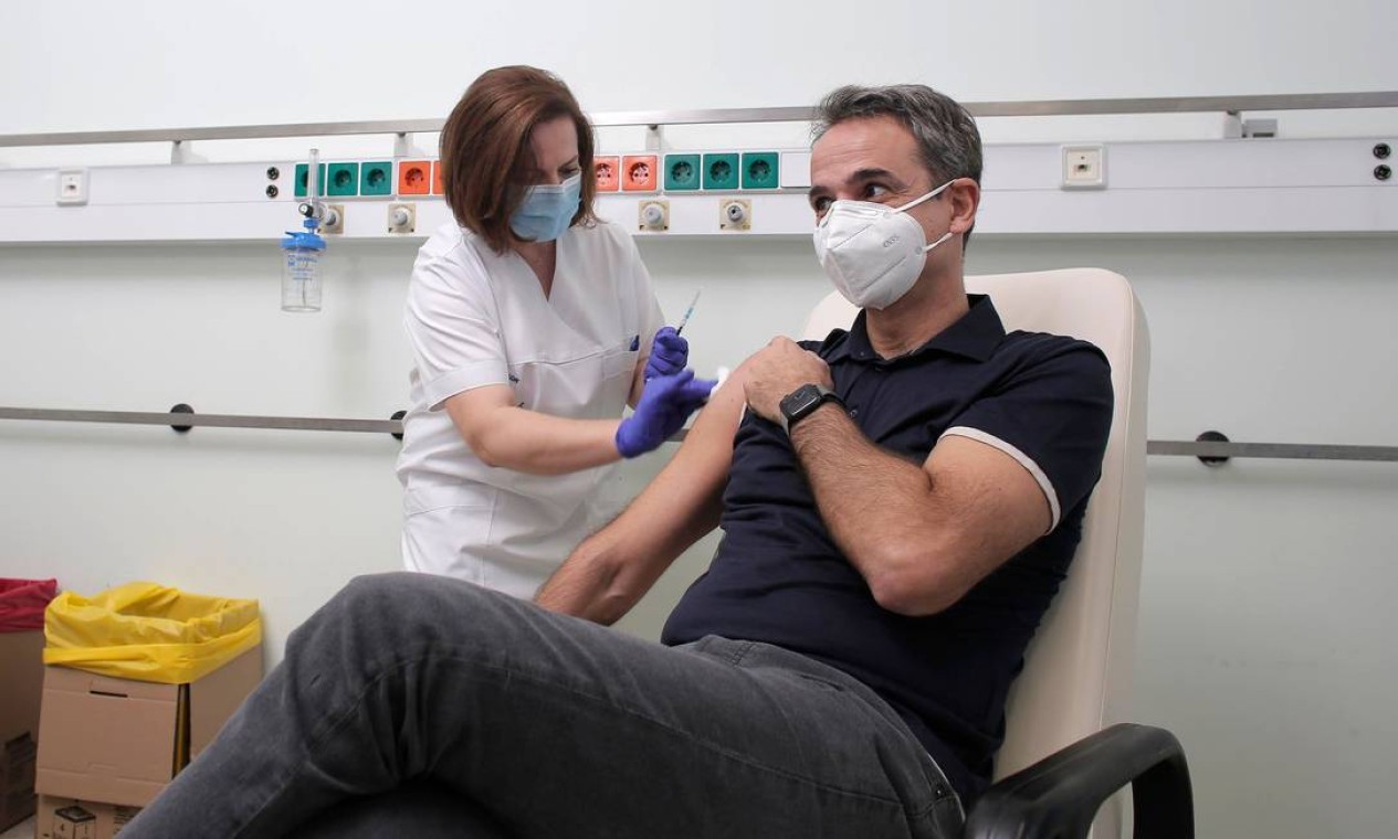 O primeiro-ministro da Grécia, Kyriakos Mitsotakis, recebe dose da vacina Pfizer/BioNTech Covid-19 no Hospital Universitário Attikon, em Atenas Foto: KOSTAS TSIRONIS / AFP - 27/12/2020