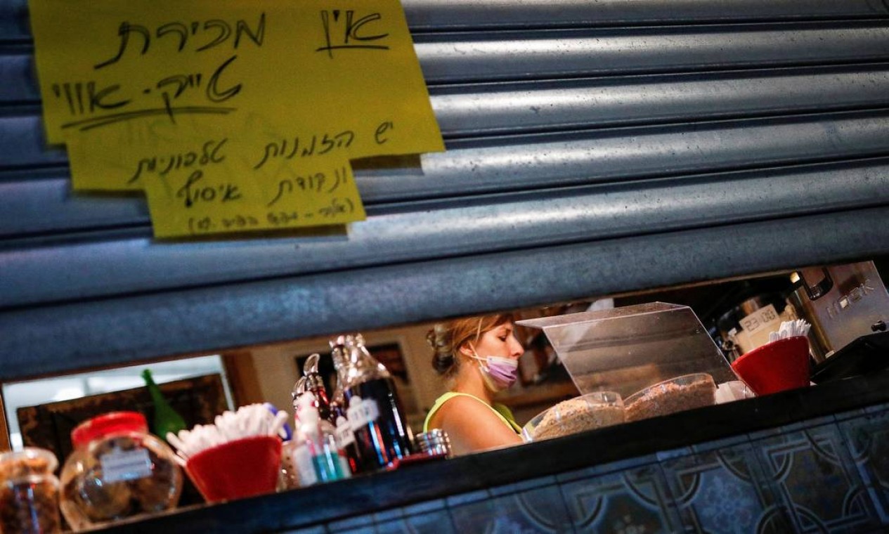 Um funcionário se prepara para fechar uma loja enquanto Israel impõe um terceiro bloqueio nacional para combater a propagação do novo coronavírus, em Tel Aviv Foto: AMIR COHEN / REUTERS