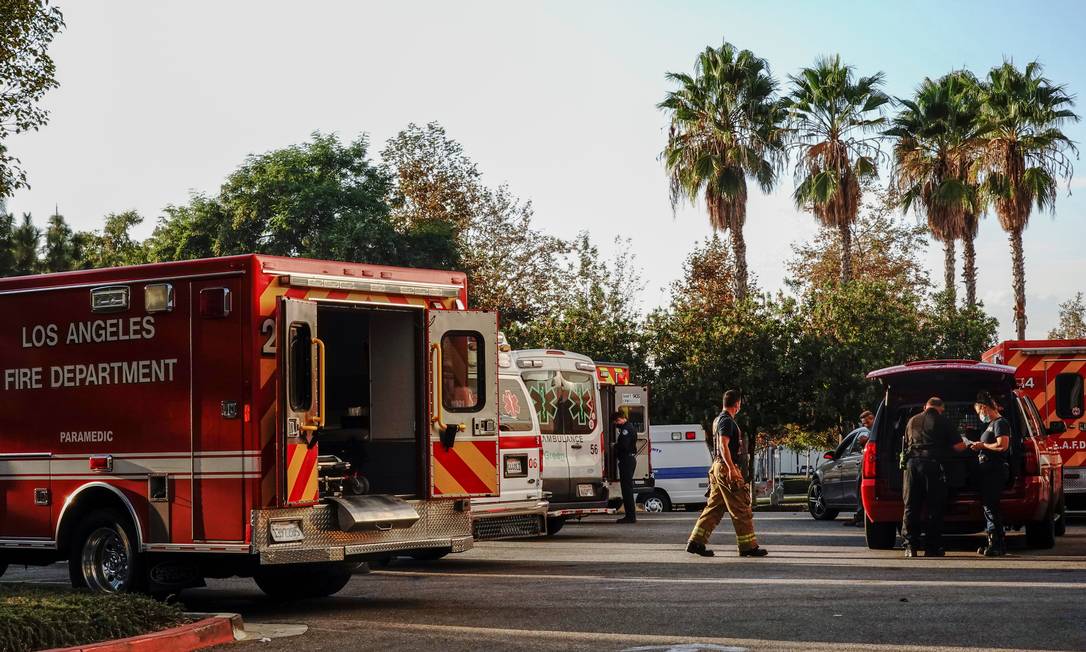 Bombeiros e paramédicos em estacionamento de hospital em Los Angeles, California, durante surto do novo coronavírus Foto: BING GUAN / REUTERS