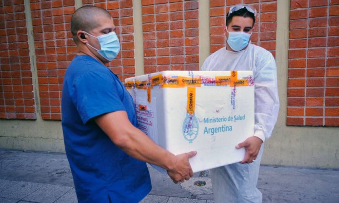Profissionais de saúde carregam uma caixa com a vacina Sputnik V em Buenos Aires, na Argentina, no dia 29 de dezembro Foto: DIEGO IZQUIERDO / AFP