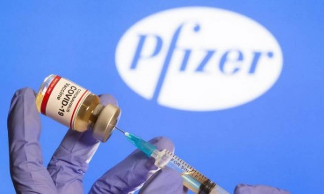 Fasco com um adesivo "Vacina Coronavírus Covid-19" diante de logotipo da Pfizer Foto: Dado Ruvic/Reuters