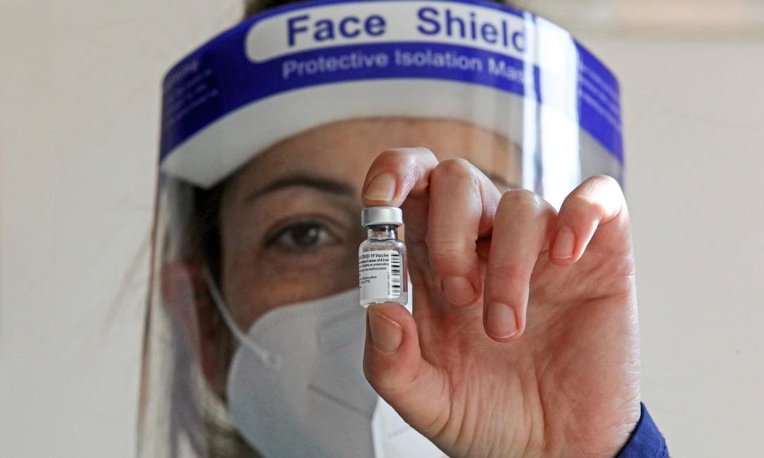 Um profissional de saúde segura um frasco da vacina Pfizer-BioNTech COVID-19 na casa de saúde Protypos Nikios Xenonas, em Nicósia, Chipre Foto: CHRISTINA ASSI / AFP