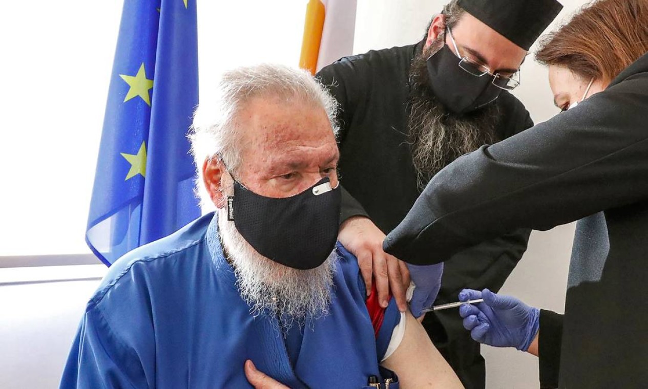 O Arcebispo Chrysostomos II de Chipre recebe sua primeira dose da vacina Pfizer-BioNTech COVID-19 no Centro de Saúde Latsia, no sul de Chipre Foto: CHRISTOS AVRAAMIDES / AFP