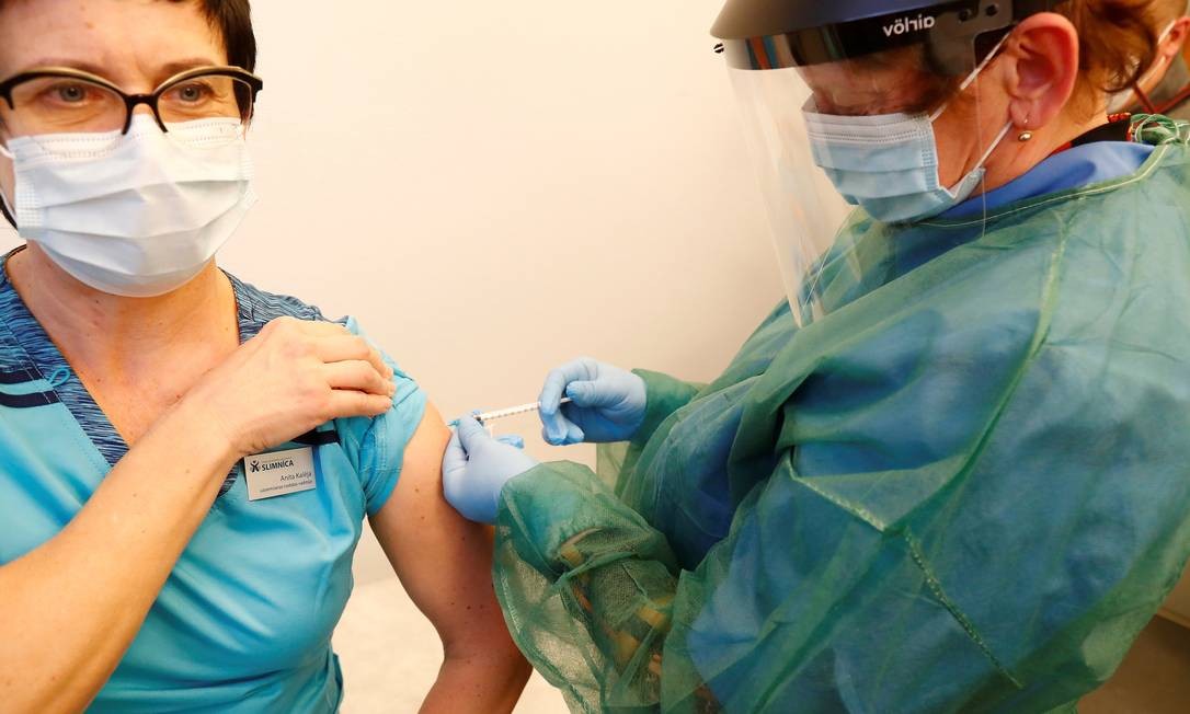 A médica especialista Anita Kaleja recebe a vacina Pfizer / BioNTech quando a Letônia inicia a vacinação contra a COVID-19, no hospital em Ventspils, Letônia Foto: INTS KALNINS / REUTERS