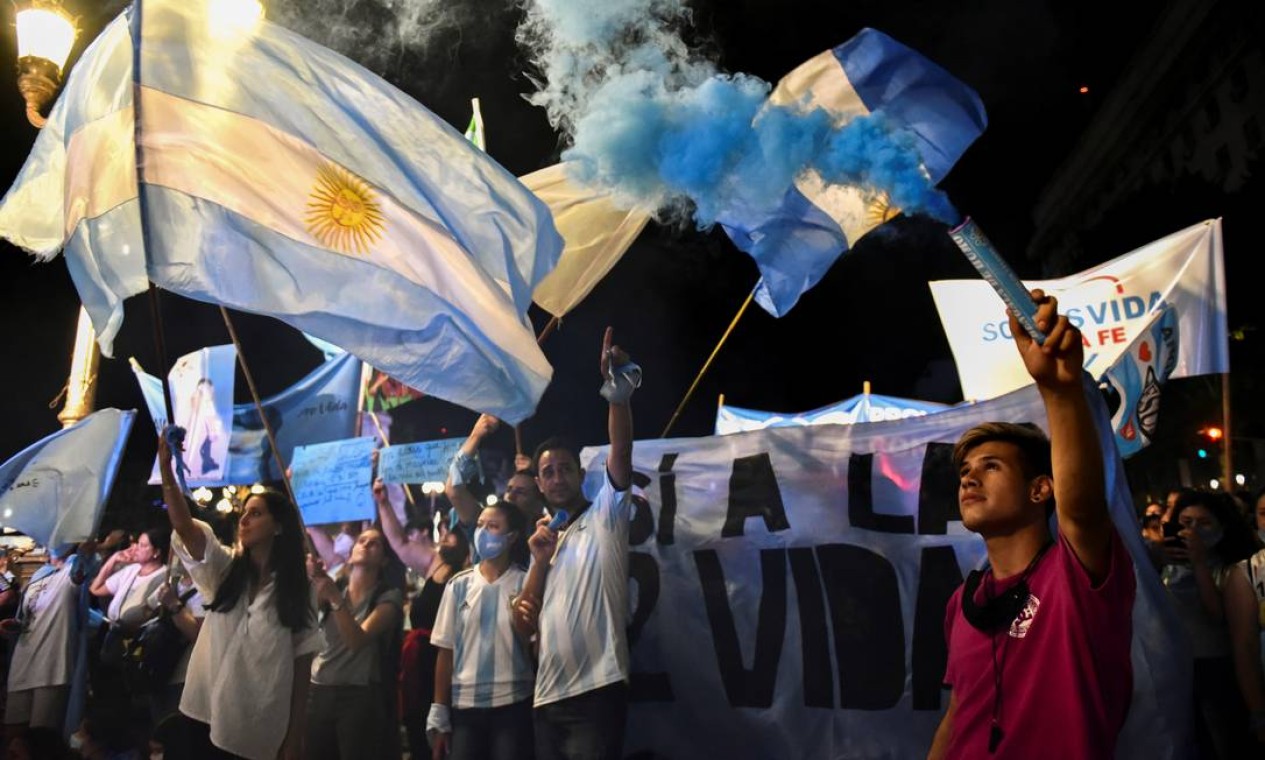 Carregando a bandeira da Argentina, manifestantes protestam do lado de fora do Congresso contra o projeto de lei que legaliza o aborto no país. O azul é a cor do movimento contrário ao aborto Foto: STRINGER / REUTERS