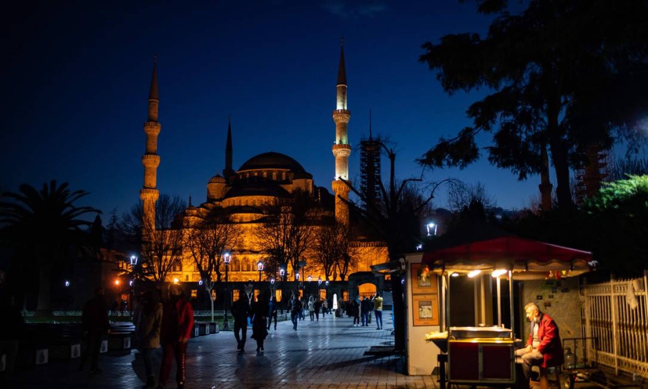 Um vendedor ambulante se senta em frente à Mesquita Azul durante as celebrações do ano novo em Istambul. O governo turco anunciou um bloqueio de quatro dias entre 31 de dezembro e 4 de janeiro de 2021 Foto: YASIN AKGUL / AFP