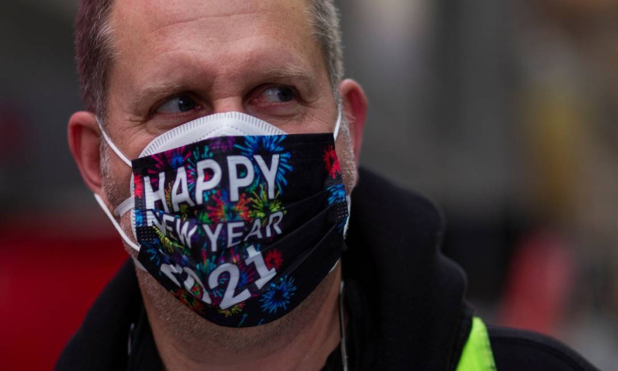Um homem usa uma máscara facial antes da celebração da véspera de Ano Novo na Times Square de Nova York Foto: KENA BETANCUR / AFP
