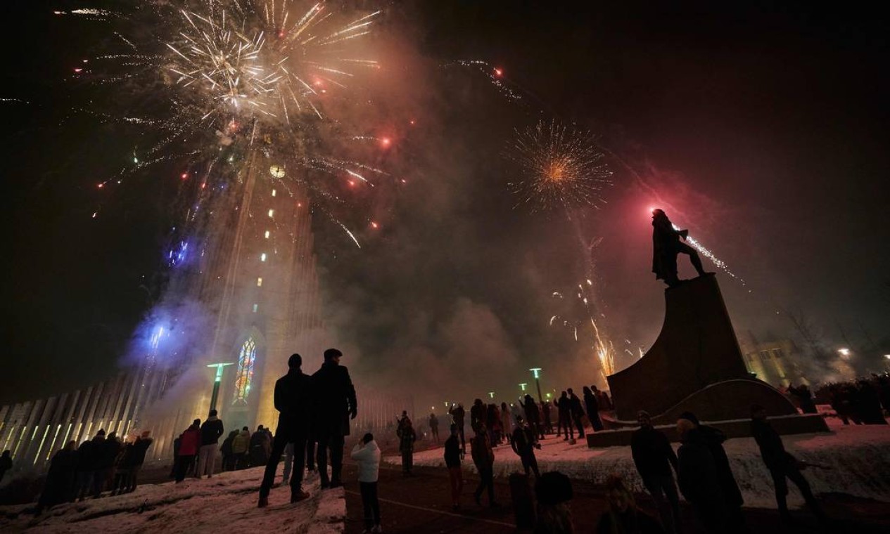 Os islandeses comemoram a chegada de 2021 com fogos de artifício iluminando o céu em Reykjavik, Islândia Foto: HALLDOR KOLBEINS / AFP