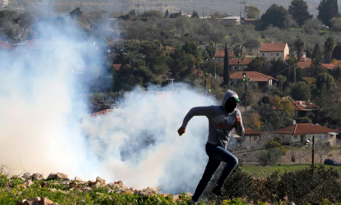 Manifestante palestino foge de gás lacrimogêneo durante manifestação contra expropriação de terras palestinas por Israel na Cisjordânia Foto: JAAFAR ASHTIYEH / AFP/01-01-2021