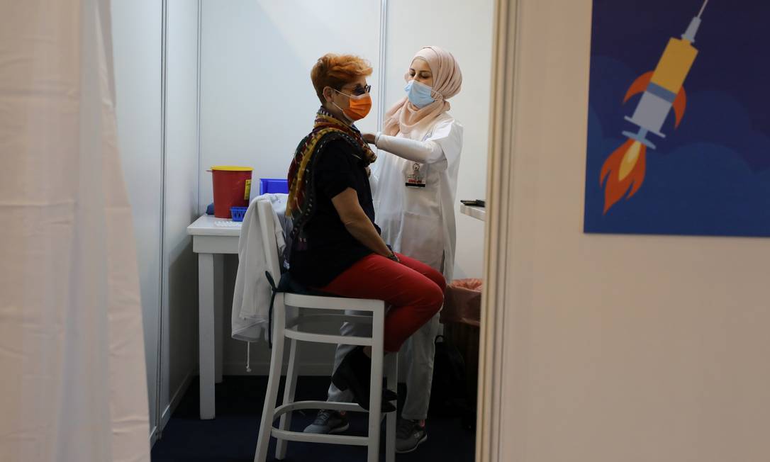 Mulher é vacinada contra a Covid-19 em Tel Aviv, Israel Foto: AMMAR AWAD / REUTERS