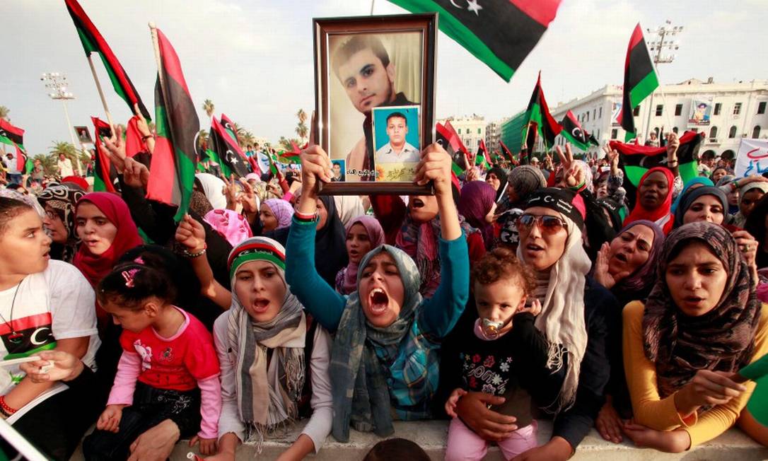 Mulher líbia carrega a foto de um parente após fim do regime de 42 anos de Muamar Kadafi Foto: Suhaib Salem / REUTERS / 23-10-2011