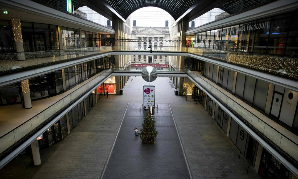 Um pedestre solitário é visto no "Mall of Berlin", o maior shopping center da capital alemã. No país, além de estender o prazo da quarentena até o fim de janeiro, os moradores das regiões onde há maior propagação do vírus terão as viagens não essenciais restritas a um raio de 15 km Foto: ODD ANDERSEN / AFP