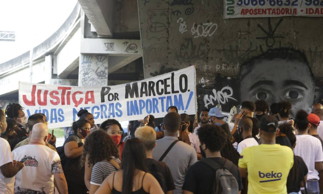 Faixa pede justiça por Marcelo. Ao fundo, grafite feito em sua homenagem, no local da tragédia Foto: Domingos Peixoto / Agência O GLOBO