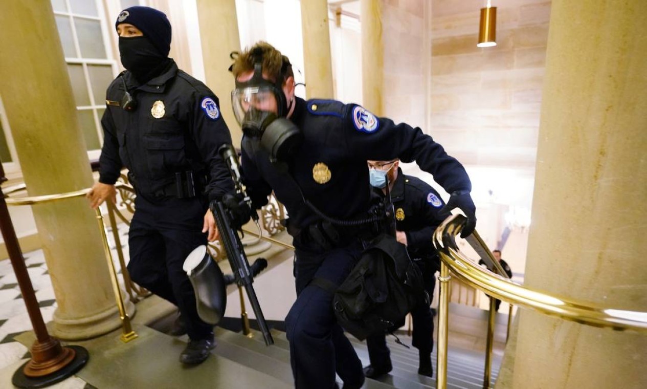 Policiais do Capitólio tomam posições enquanto os manifestantes invadem o prédio Foto: POOL / REUTERS