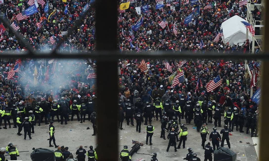 A polícia segura os apoiadores do presidente dos EUA, Donald Trump, enquanto eles se reúnem em frente à Rotunda do Capitólio dos EUA Foto: OLIVIER DOULIERY / AFP