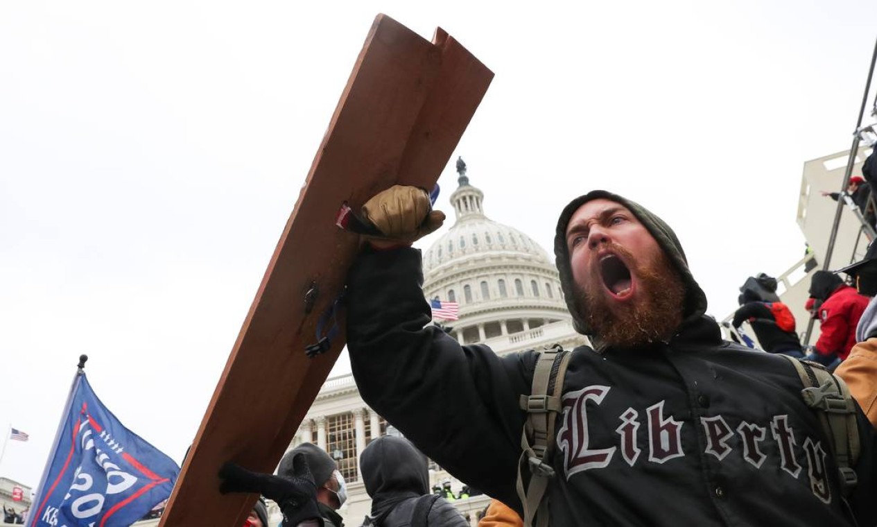 Um homem grita enquanto apoiadores de Trump se reúnem em frente ao prédio do Congresso Foto: LEAH MILLIS / REUTERS
