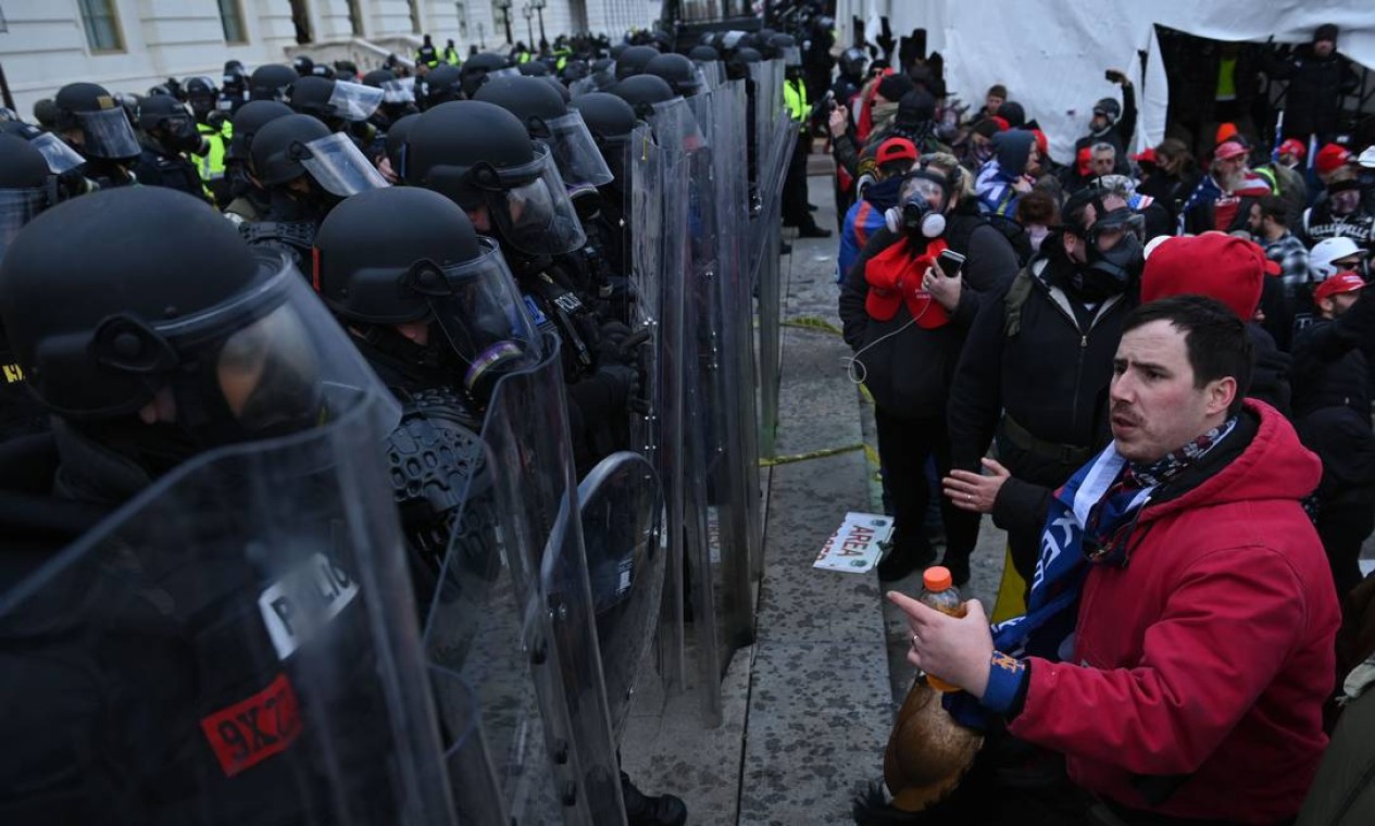 Apoiadores de Donald Trump confrontam policiais do lado de fora do Congresso americano Foto: BRENDAN SMIALOWSKI / AFP