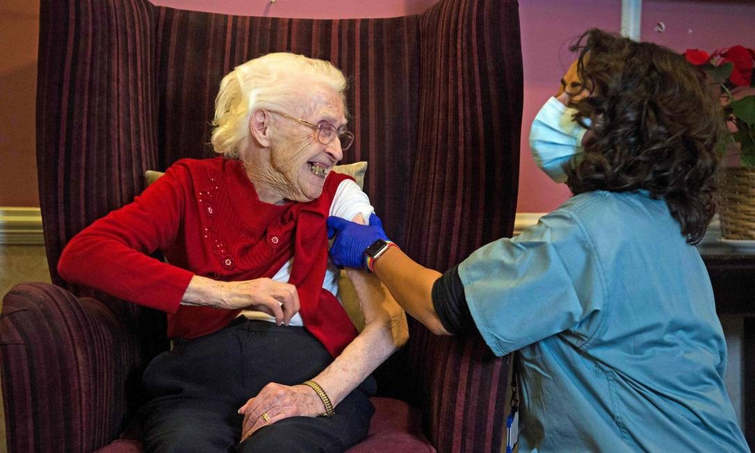Ellen Prosser, de cem anos, conhecida como Nell, recebe a vacina Oxford / AstraZeneca COVID-19 no Sunrise Care Home, em Sidcup, sudeste de Londres, Inglaterra Foto: KIRSTY O&#039;CONNOR / AFP