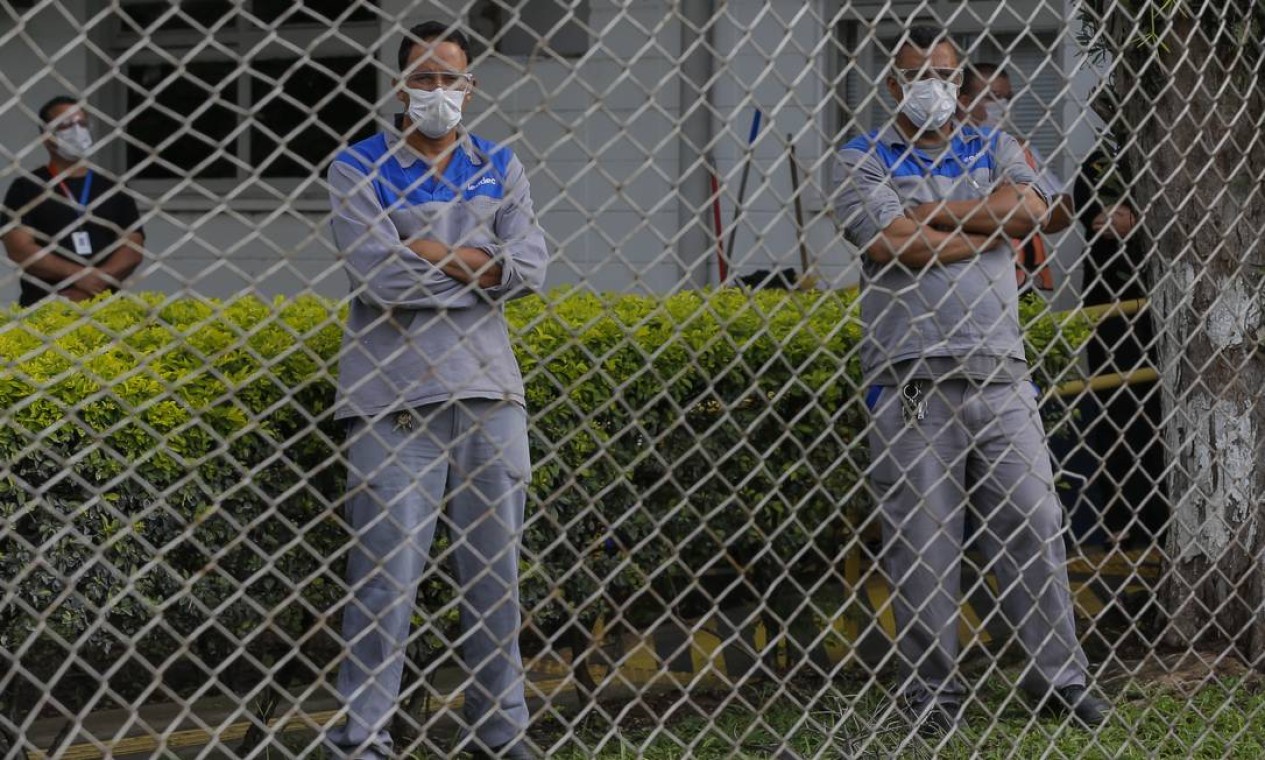 Funcionários observam manifestação de colegas contra fechamento de fábrica Foto: Agência O Globo