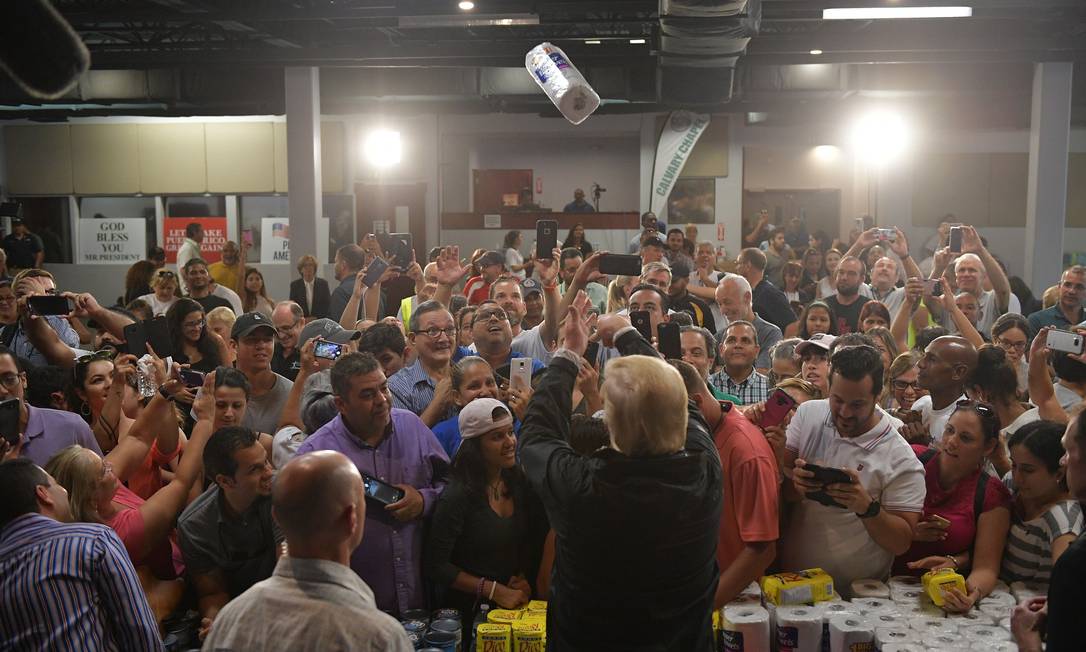 Trump, joga um rolo de papel toalha ao visitar a Capela da Cavalaria, em Guaynabo, Porto Rico, em outubro de 2017. Quase duas semanas depois que o furacão Maria atingiu o território dos Estados Unidos, muitas das ilhas continuavam sem comida e sem acesso para energia ou água potável Foto: MANDEL NGAN / AFP - 03/10/2017