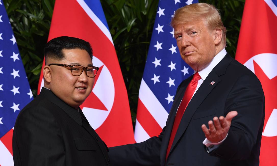 Trump acena ao se encontrar com o líder da Coreia do Norte, Kim Jong-Un no início de sua cúpula histórica EUA-Coreia do Norte, no Capella Hotel, na ilha de Sentosa, em Cingapura, em junho de 2018. Trump e Kim Jong-Un se tornaram os primeiros líderes dos Estados Unidos e da Coreia do Norte a se reunir, apertar as mãos e negociar para encerrar um impasse nuclear de décadas Foto: SAUL LOEB / AFP - 12/06/2018