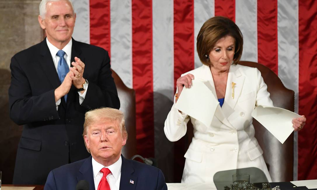O vice-presidente dos Estados Unidos, Mike Pence, aplaude enquanto a presidente da Câmara e lider dos democratas, Nancy Pelosi, rasga uma cópia do discurso de Trump após a fala do presidente americano durante o tradicional discurso anual no Congresso, em Washington, em fevereiro de 2020 Foto: MANDEL NGAN / AFP - 04/02/2020