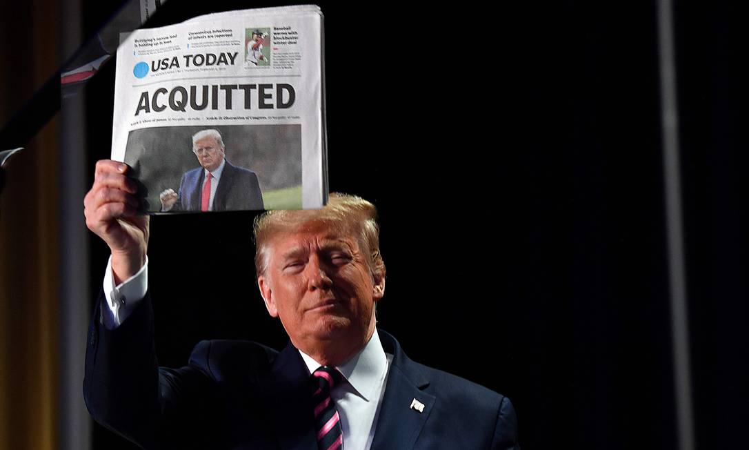 Trump mostra um jornal que exibe a manchete "Absolvido" quando chega para falar no 68º Café da Manhã de Oração Nacional, em fevereiro de 2020. O presidente disse que sofreu uma "terrível provação" durante seu impeachment Foto: NICHOLAS KAMM / AFP - 06/02/2020