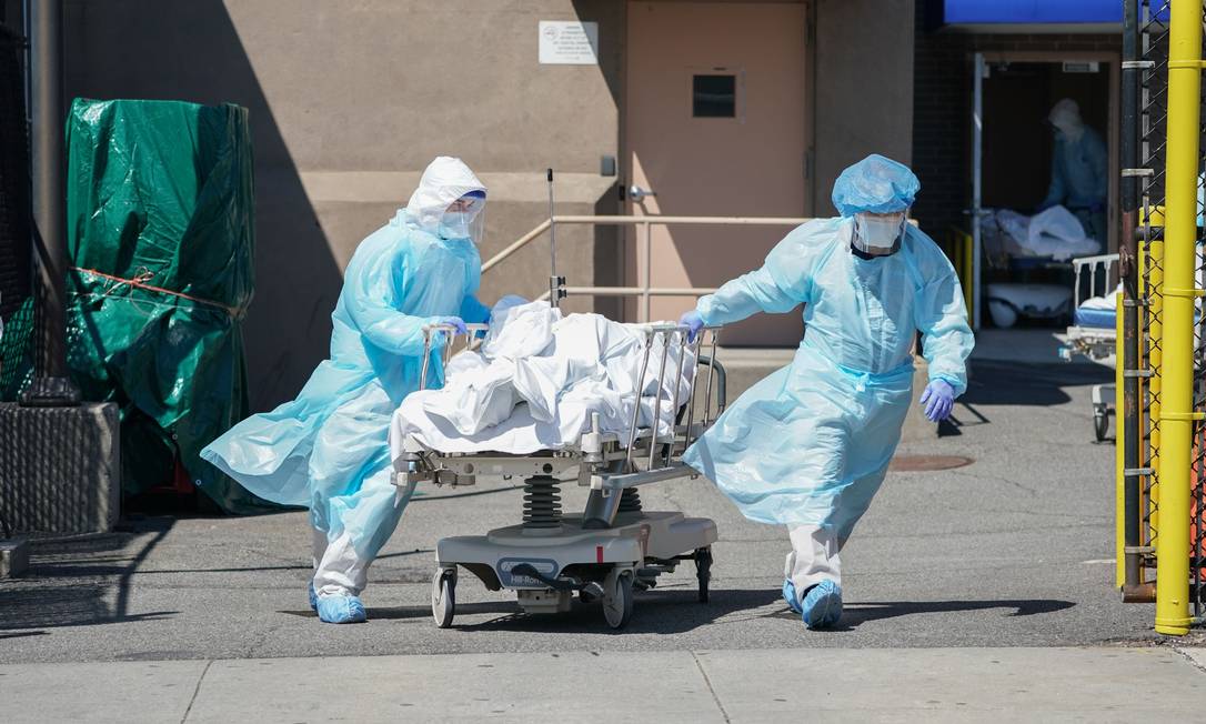 Corpos de vítimas da Covid são transferidos para um caminhão de refrigeração que serve como necrotério temporário no Hospital Wyckoff, no bairro do Brooklyn, Nova York, em abril de 2020 Foto: BRYAN R. SMITH / AFP - 06/04/2020