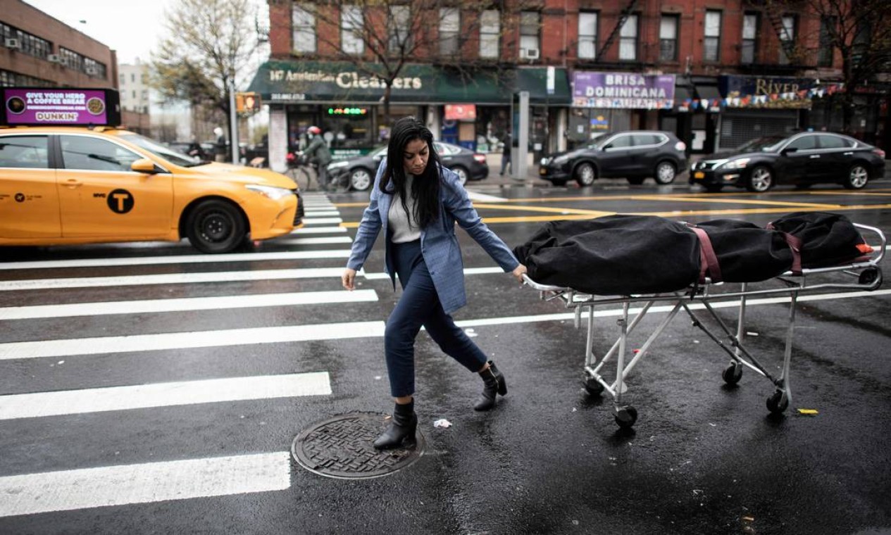 Alisha Narvaez, gerente de uma funerária, transporta um corpo no bairro de Harlem, na cidade de Nova York, em abril de 2020. Empresas do setor ficaram sobrecarregadas durante os meses de pico de mortes pelo coronavírus em Nova York Foto: JOHANNES EISELE / AFP - 24/04/2020